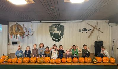 Die Kinder präsentieren stolz die Ergebnisse ihrer Kürbissschnitzkunst.