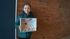 Raphael neben seinem Bild zum Thema, was Kinder tun, wenn der erste Schnee fällt. Zweitklässlerin Anna hat im Unterricht ein Bauernhof-Diorama gebastelt.