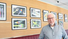 Ulrich Reiß vor seinen farbenfrohen Fotografien in der Cafeteria des Landkreises Osterholz.