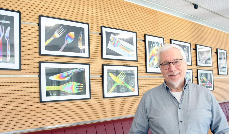 Ulrich Reiß vor seinen farbenfrohen Fotografien in der Cafeteria des Landkreises Osterholz.
