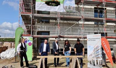 Unter der Aufsicht eines Zimmermanns werden von der Stadt und den Betreibern symbolisch die letzten Nägel des Dachstuhlbalkens versenkt.