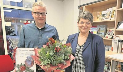 Verlagsassistenz Christina Rotondo-Renken überreichte Thorsten Vogt den Strandkorb-Gutschein sowie Blumen für seine Frau Bärbel, die zu der Zeit nichtsahnend im Kirchenbüro saß.