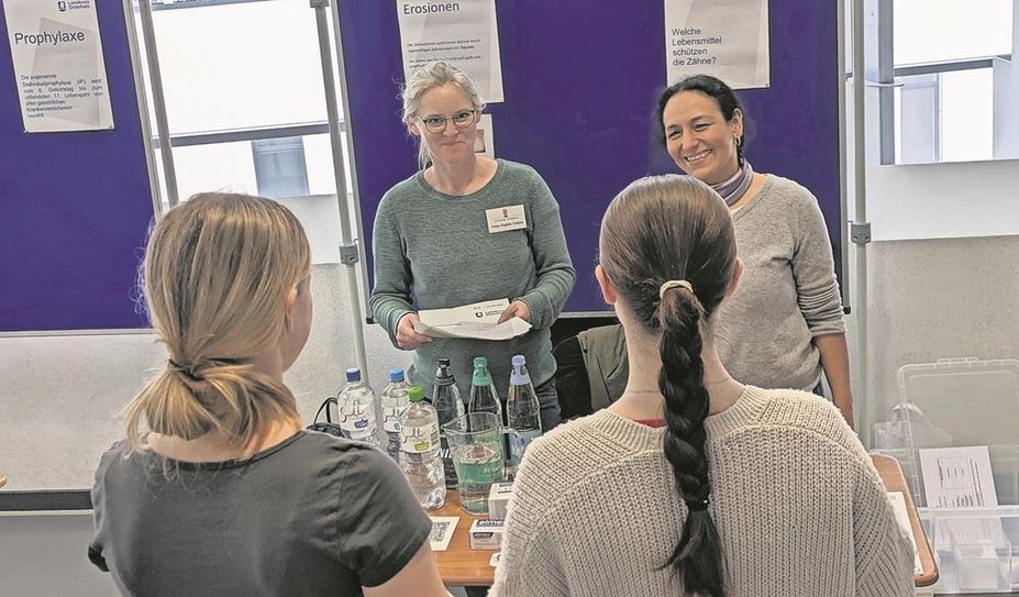 Anna Soltau und Seniz Deniz vom Gesundheitsamt im Gespräch mit zwei Schülerinnen.