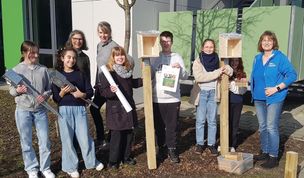 Die Kinder der Garten- und Nachhaltigkeits-AG nehmen freudig die Forscher-Nisthilfen von der NABU Umweltpyramide entgegen.