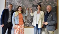 (v. l.) Rolf Eckhoff, Natascha Metzner, Britta Behrmann und Michael Hannebacher freuen sich auf die neue Kindertagesstätte - die beiden Frauen zeigen dabei auf der Luftaufnahme die Stelle, an der sie gebaut wird.