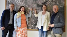 (v. l.) Rolf Eckhoff, Natascha Metzner, Britta Behrmann und Michael Hannebacher freuen sich auf die neue Kindertagesstätte - die beiden Frauen zeigen dabei auf der Luftaufnahme die Stelle, an der sie gebaut wird.