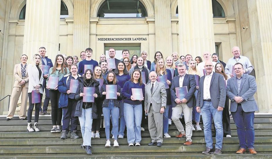 Die Europassinhaber:innen präsentieren sich mit dem Staatssekretär Dr. Jörg Mielke (vorne, grauer Anzug) vor dem Niedersächsischen Landtag.