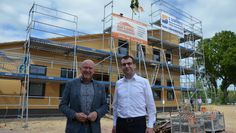Zwei Bürgermeister, ein gutes Gefühl: Michael Hannebacher (links) und der Iselersheimer Ortsbürgermeister Matthias Haak blicken zufrieden auf den Rohbau des neuen Dorfgemeinschaftshauses.