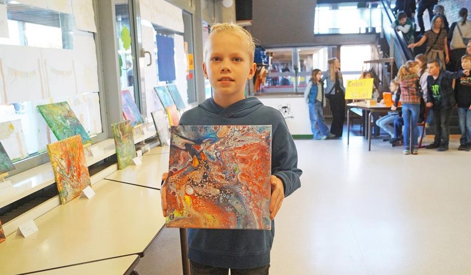 Jonas Stelling aus der 4b zeigt stolz sein mit der Acryl-Gießtechnik entstandenes Bild.