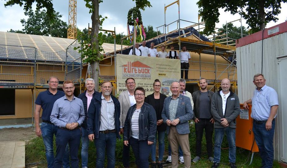 Die Richtkrone zeigt den Baufortschritt bei der neuen Kita am See. Alle Akteure freuen sich, wenn die Kita in Betrieb genommen werden kann.