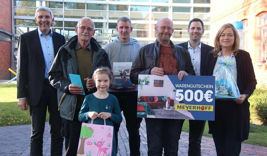 Die Gewinner:innen des Herbstmarkt-Ratespiels mit Organisator:innen und Sponsoren vor dem Rathaus.