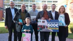 Die Gewinner:innen des Herbstmarkt-Ratespiels mit Organisator:innen und Sponsoren vor dem Rathaus.