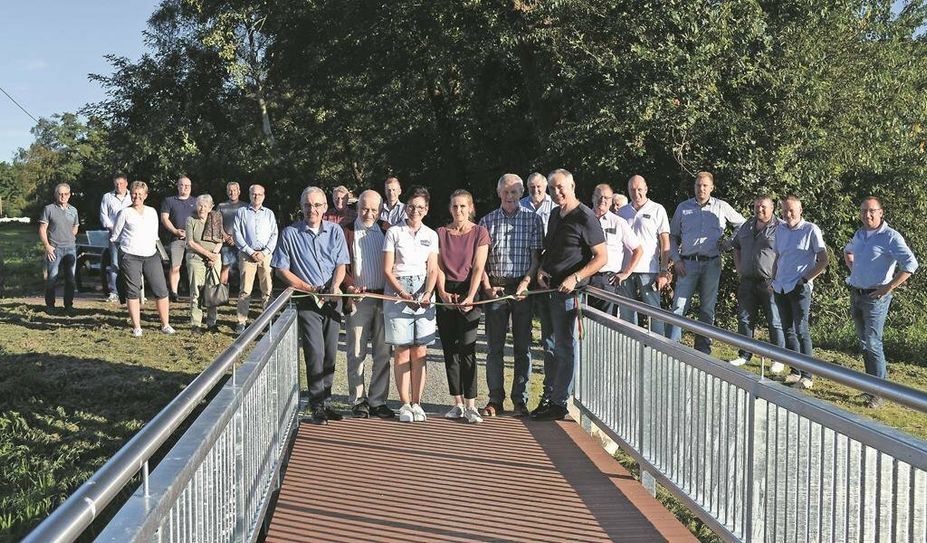 Holger Meyer (v. li.), Michael Schwieger, Birgit Tschierschke, Melanie Steffens, Johann-Martin Hildebrandt und Jens Junge durchtrennen feierlich das Band auf der neuen Brücke über den Mühlenbach.