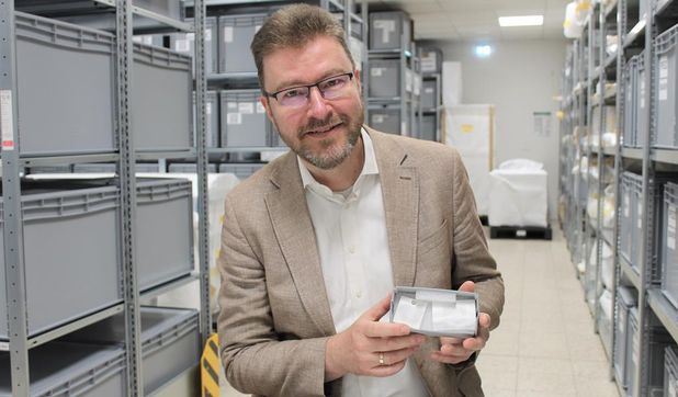 Dr. Stefan Hesse präsentiert das Stofffragment der Moorleiche. Dieser ist sehr empfindlich und wird daher nur zu Forschungszwecken aus seiner aufwendigen und sicheren Verpackung genommen.