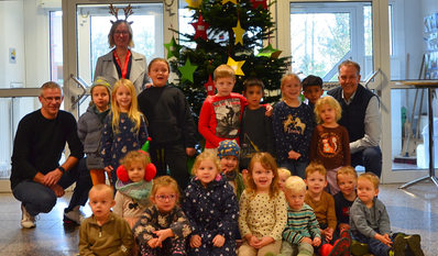 Guido Dieckmann (hinten rechts) mit Claudia Lühmann (hinten links), Kai Wilkens (links) und den Kita-Kindern vor dem Baum.
