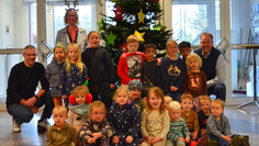 Guido Dieckmann (hinten rechts) mit Claudia Lühmann (hinten links), Kai Wilkens (links) und den Kita-Kindern vor dem Baum.