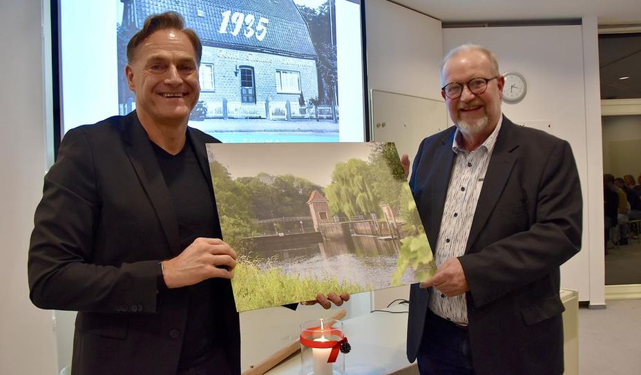 Boris Thomas (links) verabschiedet Projektmanager Manfred Mühler mit einem Bild.