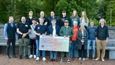 Strahlende Gesichter bei Veranstaltenden und Vereinsvertretenden bei der symbolischen Scheckübergabe.