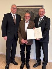 Landrat Bernd Lütjen und Axel Miesner (CDU ) überreichten Manfred Sievers seine Ehrung im Dorfgemeinschaftshaus Adolphsdorf.