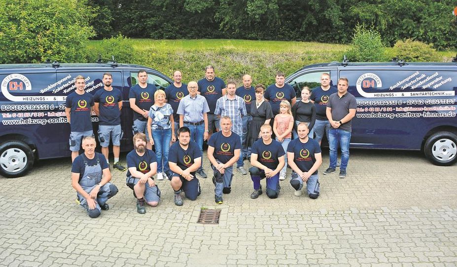 Dieter Hinners (Mitte, 2. v. li.) hat sich fürs Gruppenbild mit seiner Familie und seinen Mitarbeitenden aufgestellt.