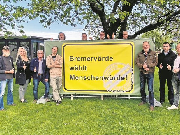Kathrin Nübel (sechste von links), Bürgermeister Hannebacher (rechts), einige Ortsvorsteher der Bremervörder Ortschaften sowie weitere an der Aktion beteiligte Personen präsentieren das Banner.