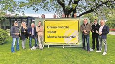 Kathrin Nübel (sechste von links), Bürgermeister Hannebacher (rechts), einige Ortsvorsteher der Bremervörder Ortschaften sowie weitere an der Aktion beteiligte Personen präsentieren das Banner.