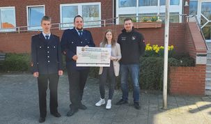 Merla Beinkehr überreicht der Kinder- und Jugendfeuerwehr einen Scheck in Höhe von 1.000 Euro.