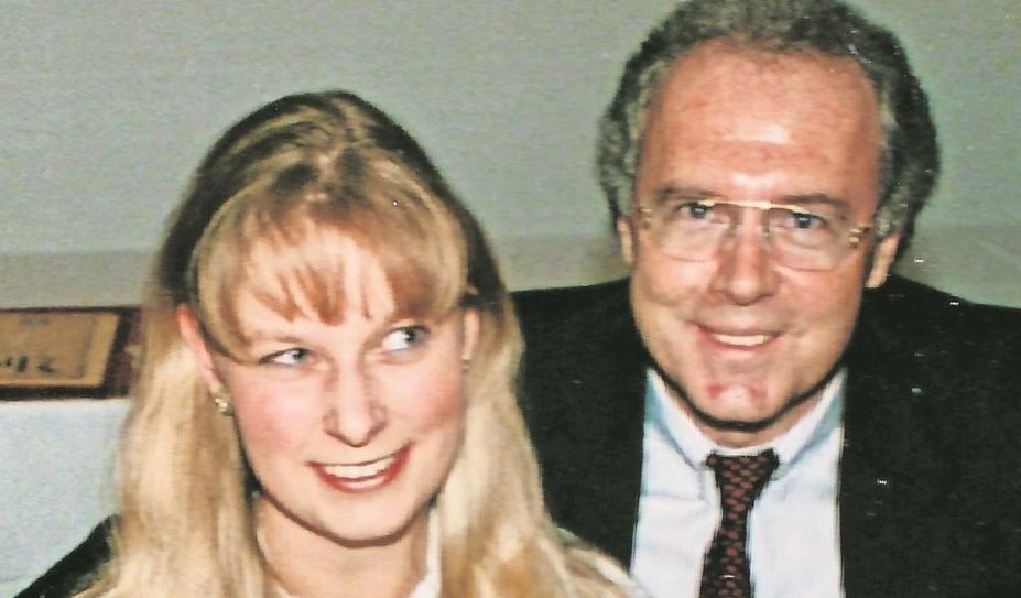 Franz Beckenbauer überreicht Katja Burmeister an einem Ehrenabend Blumen.