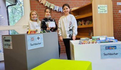 Die Kinder der Schule Geestequelle freuen sich über neue Büchertröge für die Schulbücherei.