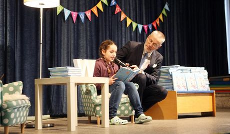 Viertklässlerin Viktoria las ihre Geschichte den Mitschülern der ersten Klasse vor, assistiert von Heinrich Schünemann vom gleichnamigem Bremer Verlag