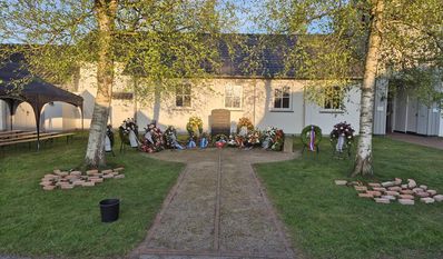 Am Gedenkstein für die im Stalag X B gestorbenen Kriegsgefangenen und KZ-Häftlinge werden weitere Kränze niedergelegt.
