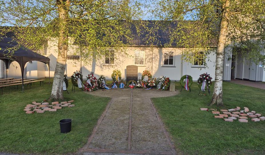 Am Gedenkstein für die im Stalag X B gestorbenen Kriegsgefangenen und KZ-Häftlinge werden weitere Kränze niedergelegt.