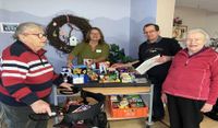 Monja Nagel und Peter von Geest (hinten, v. li.) mit zwei Bewohnerinnen am fahrbaren Kiosk.