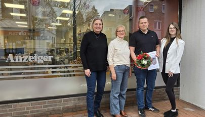 Herausgeberin Anja Kalski (li.) und Auszubildende Alea-Celine Cohrs bei der Übergabe des Hauptgewinns an Renate Dibbern und ihr Sohn Lars.