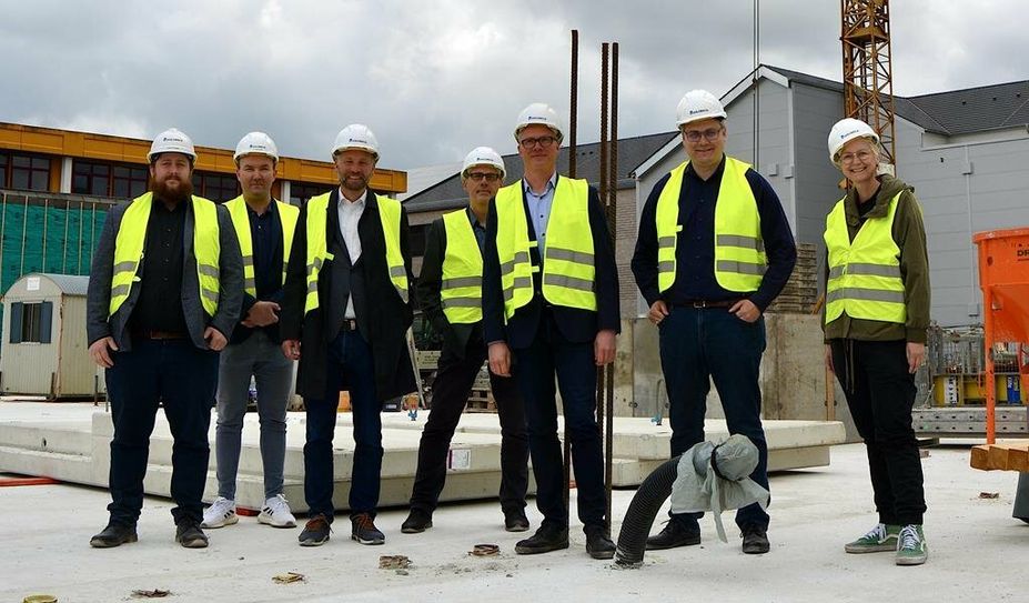 André Thomas und Christopher Grunow von der Firma Goldbeck (v. li.), Dr. Torsten Lühring, Lars Leminski, Andreas von Fintel, Landrat Marco Prietz und Dezernentin Dr. Silke Fricke auf der Baustelle.