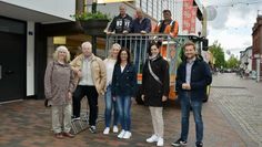 Mitarbeiter vom städtischen Bauhof (im Baggerkorb), Mitglieder des Ortsrates und BSCM-Managerin Bärbel Hensel (2 v.r.) sowie Ortsbürgermeister Dirk-Frederik Stelling (re.) freuen sich über die neu angebrachte Blumenpracht.