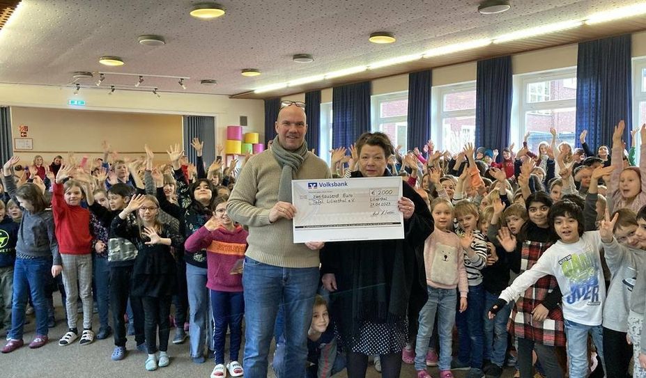 Lilienthal. Schüler:innen der Schroeterschule sammelten 2.000 Euro für die Tafel Lilienthal. Inga Ahsen nahm für die Tafel den symbolischen Scheck von Schulleiter und 200 stolzen Schüler:innen entgegen.