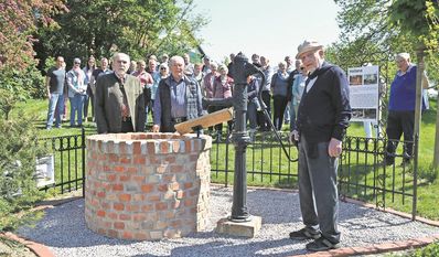 Dr. Udo Lade (v. li.), Heinz von Kamp und Michael Schwieger freuen sich mit zahlreichen Hollenern über das neue Wahrzeichen in der Ortsmitte.