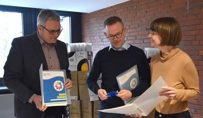 Landrat Marco Prietz (v. li.), Gerd Hachmöller und Franziska Wronka beim Durchschauen der neuen Willkommensmappen.