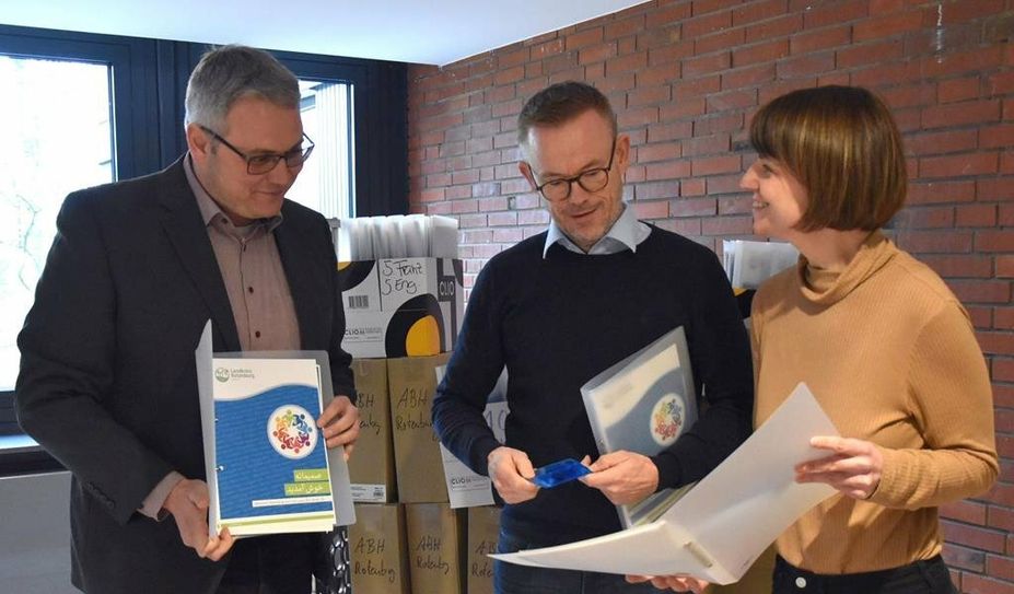 Landrat Marco Prietz (v. li.), Gerd Hachmöller und Franziska Wronka beim Durchschauen der neuen Willkommensmappen.