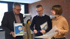 Landrat Marco Prietz (v. li.), Gerd Hachmöller und Franziska Wronka beim Durchschauen der neuen Willkommensmappen.