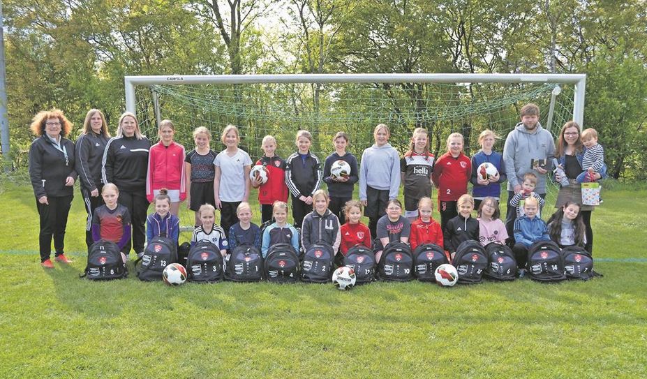 Das Trainerteam und die Nachwuchsfußbalerinnen bedanken sich bei Familie Haak (rechts) für die Rucksäcke.