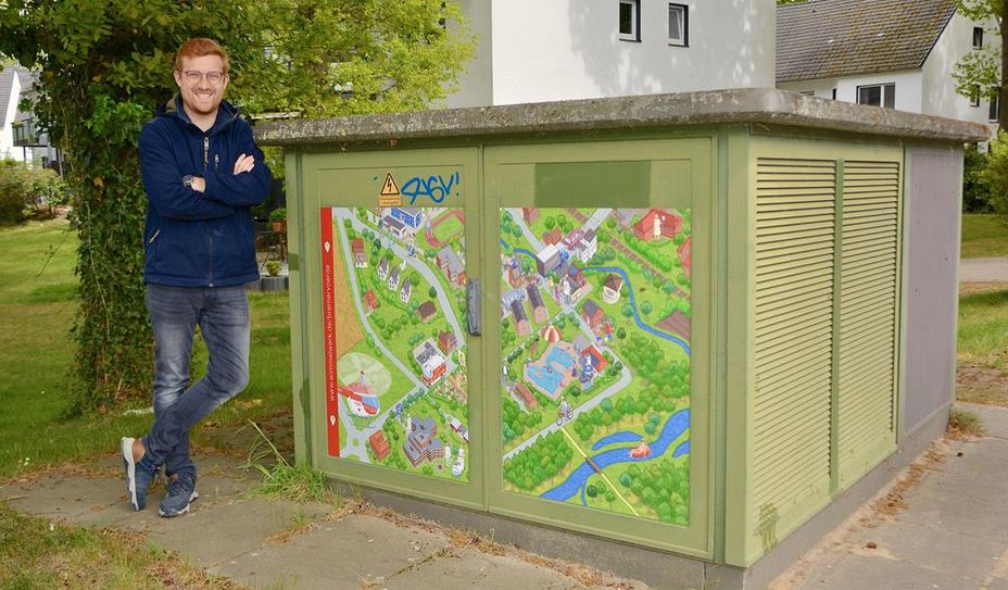 Ortsbürgermeister Dirk-Frederik Stelling freut sich über das Wimmelbild beim Schwimmbad.