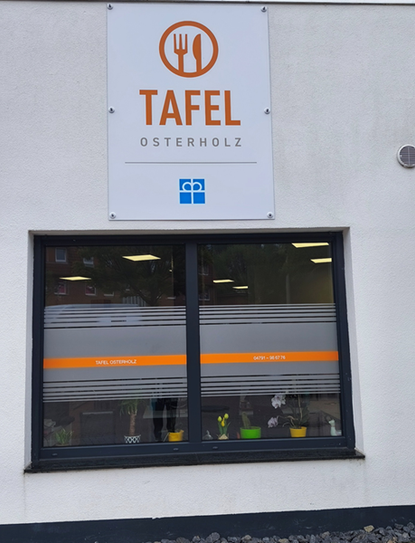 Neues Schild und Fensterbeklebungen machen die Osterholzer Tafel in der Kirchenstraße auch von außen deutlich erkennbar.
