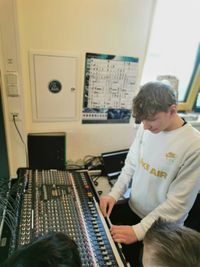 Mitarbeiter der Abteilung Oereler Music and Dancecorporation erklärt Schülern das Mischpult.