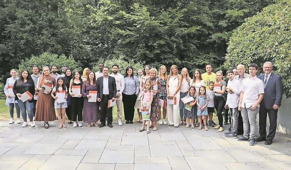 Freuen sich über ihre neue Staatsbürgerschaft: Die neuen Bürger:innen von Osterholz mit Landrat Bernd Lütjen (rechts).