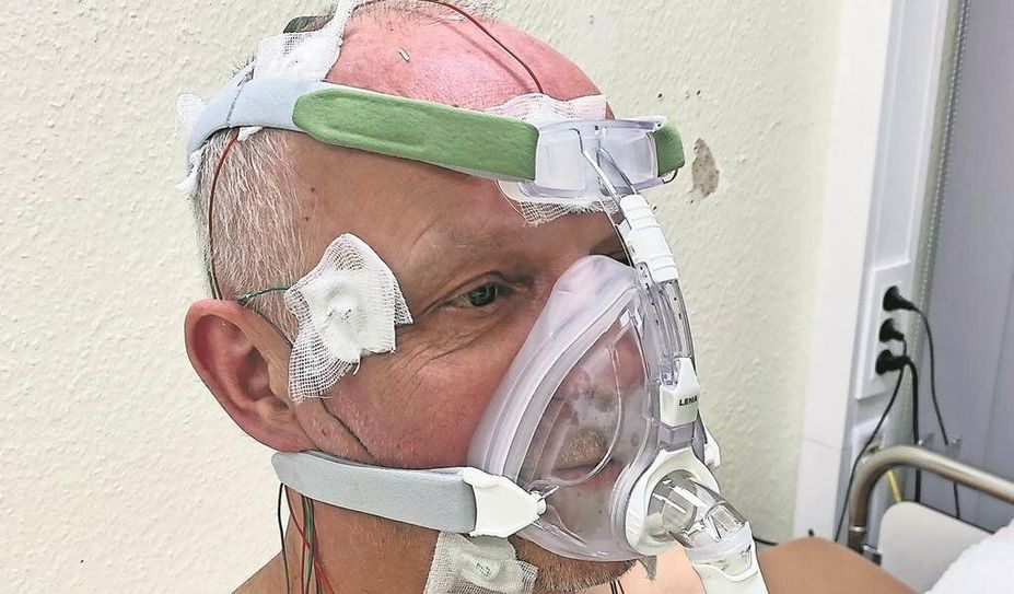 Unser Autor mit den Messgeräten am zweiten Tag im Schlaflabor. Wenn die Schlafmaske zuhause genutzt wird, ist der Oberkörper nicht verkabelt – es wird im täglichen Gebrach also lediglich die Maske genutzt.