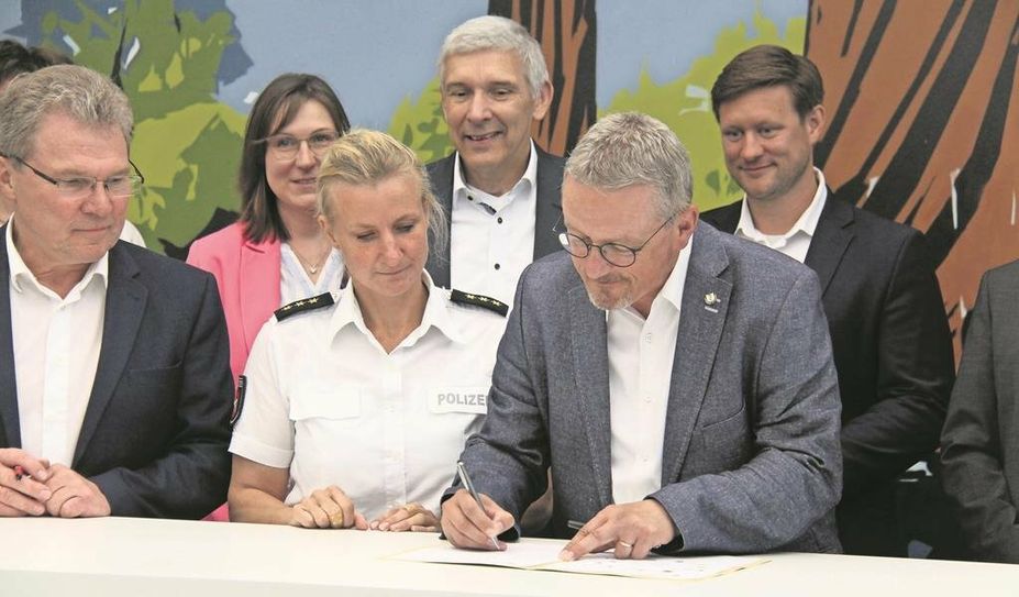 Landrat Bernd Lütjen (vorne rechts) unterzeichnet die Sicherheitspartnerschaft mit der Polizei im Namen des Landkreises. Die Bürgermeister:innen der Gemeinden folgten. Foto: jm