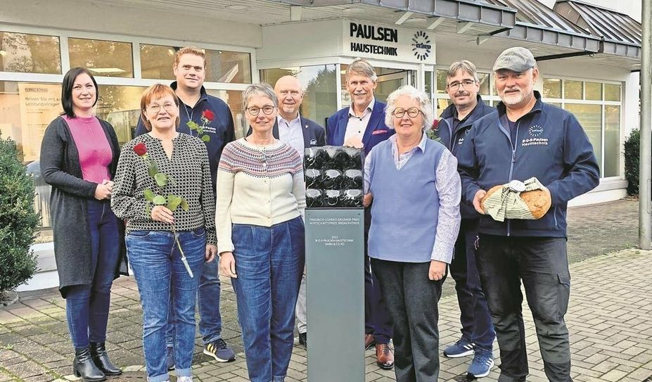 Sabine Schneider (vorne, 2. v. li.) und Barbara Illig (vorne, 3. v. li.) freuen sich mit Vertretenden der Stadt und von der B-G-S Paulsen über je 1.000 Euro für den Nachbarschaftsladen und die Krebsfürsorge.