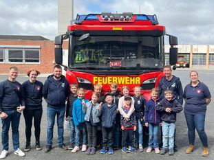 Gruppenfoto vor dem Einsatzfahrzeug